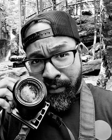 Jordan, holding a camera on a forest trail